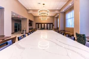 una gran sala de conferencias con una gran mesa blanca y sillas en Hampton Inn & Suites Sugar Land, Tx, en Sugar Land