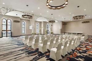 a conference room with white chairs and a stage at Hampton Inn Indianapolis Downtown IUPUI in Indianapolis