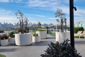 een groep witte potten met bomen op een dak bij Breathtaking City & River Views HUGE Balcony! in Melbourne