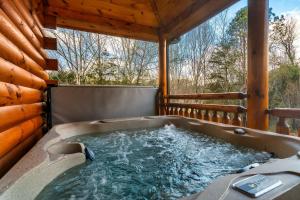 bañera de hidromasaje en la cubierta de una cabaña en Lykke Lodge, en Pigeon Forge 1 foto más