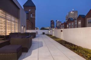 a sidewalk with tables and chairs on a building at Homewood Suites by Hilton Indianapolis Downtown IUPUI in Indianapolis