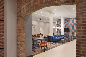 an open lobby with a brick wall and chairs at Homewood Suites by Hilton Indianapolis Downtown IUPUI in Indianapolis