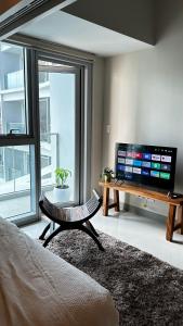 a living room with a flat screen tv and a table at Uptown Parksuites - BGC, Manila in Manila