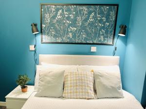 - une chambre avec des murs bleus et un lit avec deux oreillers dans l'établissement Dublin Central Apartment, à Dublin