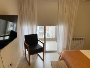 1 dormitorio con silla frente a una ventana en Espacio 20, en Salta
