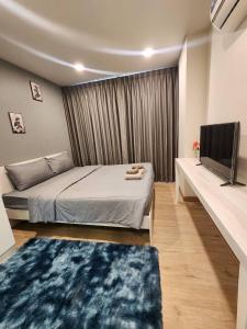 a bedroom with a bed and a flat screen tv at The East Ville in Ban Hua Khao Sammuk