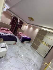 - une chambre avec 2 lits et un sol en marbre dans l'établissement شقة مفروشة للايجار بالمهندسين, au Caire