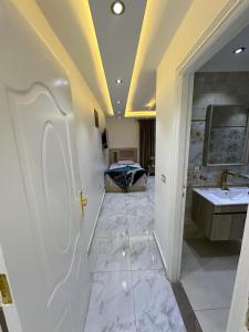 - une grande salle de bains avec deux lavabos et un lit dans l'établissement شقة مفروشة للايجار بالمهندسين, au Caire