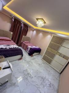 een slaapkamer met 2 bedden en een kroonluchter bij شقة مفروشة للايجار بالمهندسين in Caïro