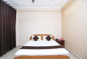a bedroom with a bed with a wooden headboard at OYO 10216 Hotel UK Retreat in Bhowāli