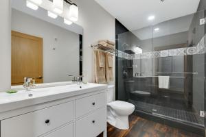 a bathroom with a sink and a toilet and a shower at Magnolia Suite - Main Street Lodge in Berlin in Berlin