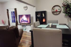 ein Wohnzimmer mit einem Esstisch und einem TV in der Unterkunft Downtown Charm Two Bedroom Home in Noblesville