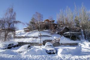 eine Gruppe von Autos, die im Schnee geparkt sind in der Unterkunft La Cornisa Lodge in Santiago