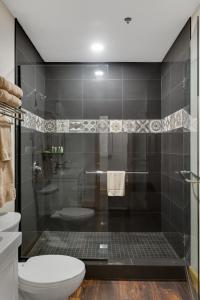a bathroom with a shower with a toilet and a sink at Magnolia Suite - Main Street Lodge in Berlin in Berlin