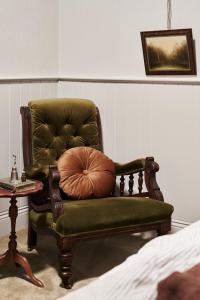 a green chair with a pillow in a room at Luxury Bendigo Stay in Golden Square