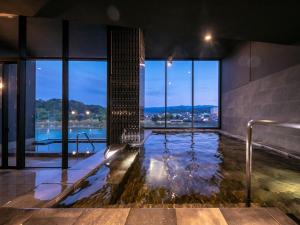 a swimming pool in a building with a view at Hitoyoshi Onsen Nabeya in Hitoyoshi