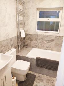 a bathroom with a toilet and a tub and a sink at Park Lane Ground Floor Apartment - Workington Town Centre Location - Free Overnight parking in Workington