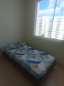 a bed in a room with a window at para estrenar girardot in Soacha