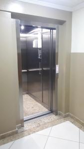 a elevator in a building with a glass door at Vila Santa Hotel in Aparecida