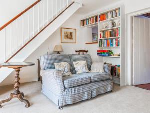 a living room with a couch and a book shelf at Middle Cottage in Letheringsett