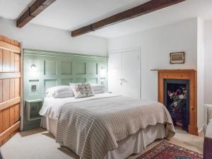 a bedroom with a large bed and a fireplace at Middle Cottage in Letheringsett