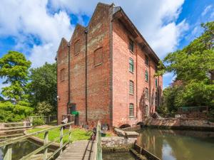 an old brick building next to a river at Middle Cottage in Letheringsett