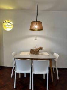 een eettafel met twee witte stoelen en een lamp bij Departamento perfectamente ubicado in Mendoza