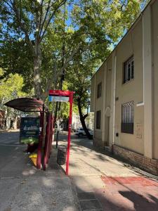 a red bus stop on the side of a street at Departamento perfectamente ubicado in Mendoza