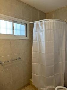 een badkamer met een douche met een wit douchegordijn bij Departamento perfectamente ubicado in Mendoza