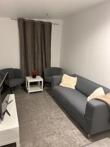 ein Wohnzimmer mit einem Sofa und einem Tisch in der Unterkunft Royal’Quality in Boussy-Saint-Antoine