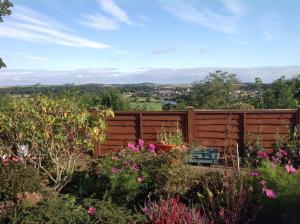 a wooden fence in a garden with flowers at Coppertree in Kelso