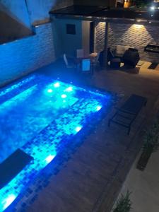 uma piscina iluminada à noite com luzes azuis em Home Aguas da barra Ilhabela em Ilhabela