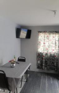 ein Esszimmer mit einem Tisch und einem Vorhang in der Unterkunft Habitación cómoda para tu estancia, con baño privado in Mexiko-Stadt