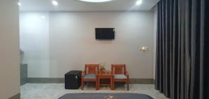ein Zimmer mit einem Tisch, zwei Stühlen und einem Fernseher in der Unterkunft Homestay Quyên Quỳnh in Cu Lao Thu