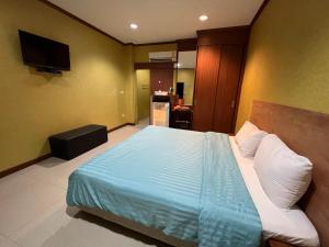 จินตคามโฮมเพลส/Jintakam Home Place في أودون ثاني: غرفة نوم بسرير وملاءات زرقاء وتلفزيون