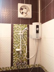 un bagno piastrellato con doccia e dispenser di sapone di จินตคามโฮมเพลส/Jintakam Home Place a Udon Thani