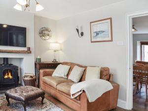 uma sala de estar com um sofá e uma lareira em Hillview Cottage em North Nibley