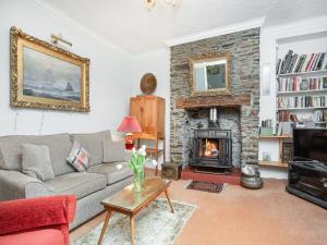 a living room with a couch and a fireplace at Lee House in Fowey