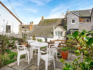 a patio with a white table and chairs and a house at Lee House in Fowey