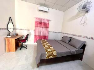 - une chambre avec un lit, un bureau et une table dans l'établissement Motel An Bình, à Dien Khanh