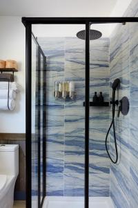 a shower with a glass door in a bathroom at Mine and Farm, The Inn at Guerneville, CA in Guerneville