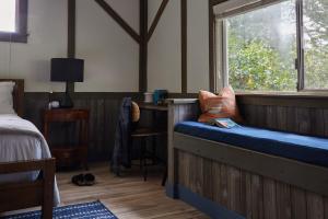 a bedroom with a bench with a window and a bed at Mine and Farm, The Inn at Guerneville, CA in Guerneville