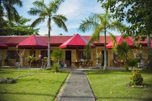 a house with red roofs and a garden at Whispering Palms Island Resort in San Carlos