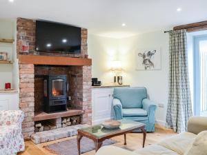 a living room with a fireplace and a tv at The Old Hemmel-uk44853 in Holton