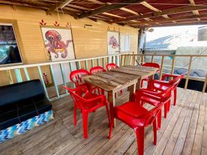 a wooden table and red chairs on a deck at Eco Hostal Estrella De Mar in Isla Mucura