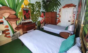 a bedroom with two beds and a painting of a mushroom at Kimberly Backpacker Hotel in Cape Town