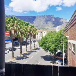 a street with palm trees and a mountain in the background at Kimberly Backpacker Hotel in Cape Town