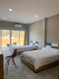 een slaapkamer met 2 bedden, een stoel en een raam bij 365 View Point Resort in Kaki Bukit