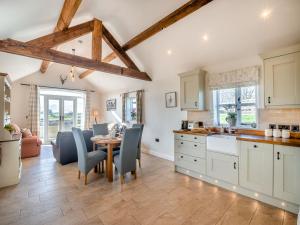 uma cozinha e sala de jantar com mesa e cadeiras em Bank House Barn em Audlem