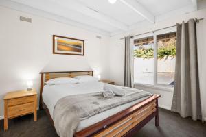 a bedroom with a large bed and a window at Torquay Boulevard Beach House in Torquay